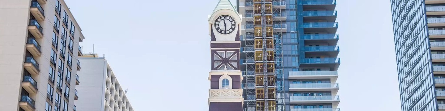 A photo of the Charles Tavern Clock Tower surrounded by development.
